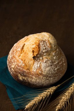 Lezzetli ev yapımı mayasız yuvarlak ekmek, buğday kulaklı bir volkan şeklinde. Kırsal bir hayat sürüyor.
