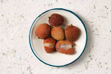 Hafif arka planda metal bir plaka üzerinde olgun tropikal liçi üzümleri.