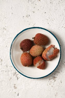 Hafif arka planda metal bir plaka üzerinde olgun tropikal liçi üzümleri.