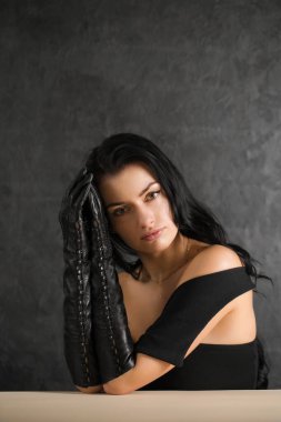 Siyah arka planda siyah eldivenli güzel siyah saçlı kadın.