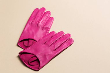 Bej bir arka planda parlak pembe bir çift eldiven