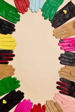 Parlak, çok renkli, modaya uygun eldivenler, bej bir arka planda süslemeler, dokuma ve perçinleme