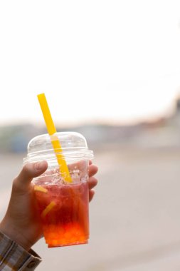 Kadının elinde köpüklü çay bardağı var, yakın plan.