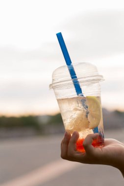 Kadının elinde köpüklü çay bardağı var, yakın plan.