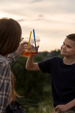 Kadının elinde köpüklü çay bardağı var, yakın plan.