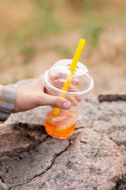 İki çocuk akşamları yürürken plastik bardaklardan köpüklü çay içer.