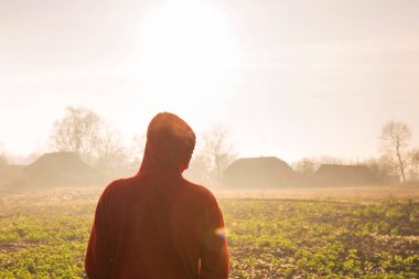 Kırsalda sisli bir sonbahar sabahının tadını çıkaran bir adamın arka portresi.
