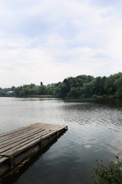Bulutlu bir günde, nehirde terk edilmiş bir ahşap iskele.