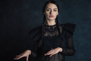 Siyah elbiseli genç bir kadın dans ediyor, Cadılar Bayramı konsepti.