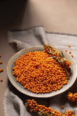 Portakal çilekli bir tabak gri bir peçeteyle bir masanın üzerinde duruyor. Organizasyon ve fayda kavramı