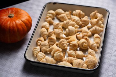 Küçük kruvasan ve kedi şeklinde kurabiyeler. Kabak kabağının yanında, beyaz bir kabağın içindeki puf böreğinden. Cadılar Bayramı yemek kavramı