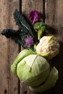 Brokoli, karnabahar ve lahana eski ahşap bir masada sade bir anahtar ile çekilmiş bir fotoğraf.