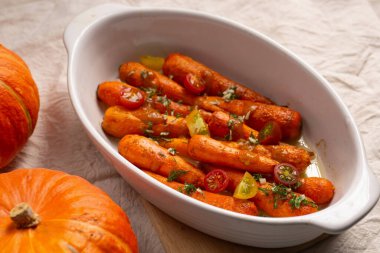 Fırında pişirilmiş beyaz seramik tabakta soslu kızarmış havuç. Şükran Günü için lezzetli bir yemek.
