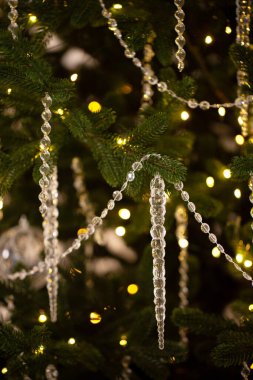 Bir sürü ışığı ve kristal süslemeleri olan bir Noel ağacı. Noel ağacındaki berrak kristal süslemelerin yakın çekimi