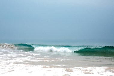 Hint Okyanusu kıyısında köpüklü güzel mavi dalgalar. Sabah bulutsuz gökyüzü