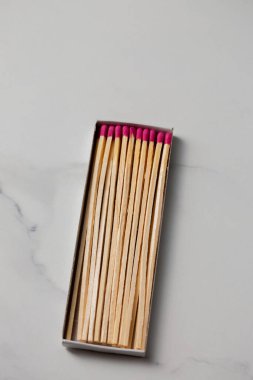 Pembe ve kırmızı saçlı bir kutu kibrit. Kutu açıldı ve kibritler dizildi.