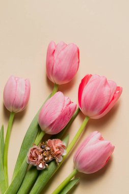 Bej arka planda pembe alt laleleri olan el yapımı el yapımı böcek broşu..