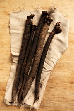 Tahta bir masanın üzerinde keten bir peçete içinde diyet tıbbi toprak sebze akrebi.