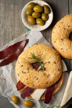 Peynirli hamburger, basturma, zeytin ve biberiye.