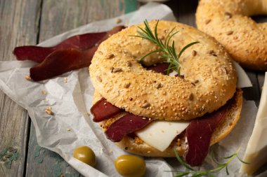 Peynirli hamburger, basturma, zeytin ve biberiye.