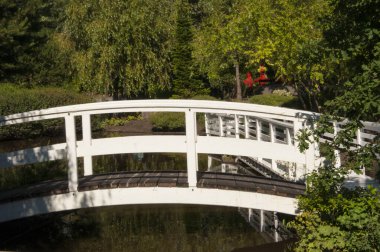 Bahçenin yanındaki küçük derenin üzerindeki beyaz ahşap köprü.