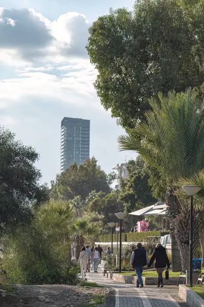 stock image Limassol, Cyprus - January 14, 2021: People walking in a seaside park in Agios Tychon area of Limassol