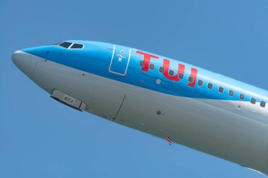 Larnaca, Cyprus - May 16, 2023: Close-up of a passenger airplane nose with TUI Airways livery during landing approach against a clear blue sky. Cyprus clipart