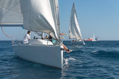 Sleek yachts vie for position in a thrilling sailing regatta on the blue mediterranean sea clipart