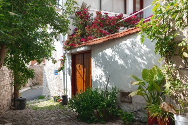 Canlı çiçeklerle süslenmiş geleneksel bir Akdeniz köyü evinin yer aldığı tuhaf, güneşli bir sokak. Laneia Köyü. Limasol İlçesi, Kıbrıs