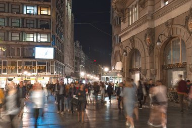 Belgrad, Sırbistan - 21 Eylül 2019: Geceleri kalabalık bir şehir sokağının bulanık yayalarla uzun süre korunması