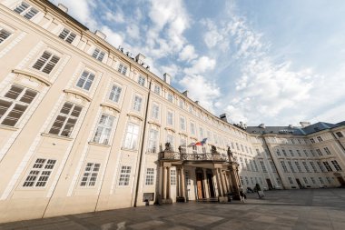 Prag Kalesi 'nde penceresi ve bayrağı olan tarihi bir binanın dış görünüşü. Çek Cumhuriyeti