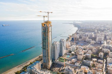 Modern bir şehrin kıyısında tamamlanmamış bir gökdelen inşa ediliyor. Limasol, Kıbrıs