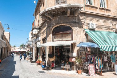 Lefkoşe, Kıbrıs - 24 Ekim 2022: Lefkoşe 'de dar bir sokakta yürüyen turistler, giyim, hediyelik eşya ve yerel mallar satan dükkanlarla sıralandı