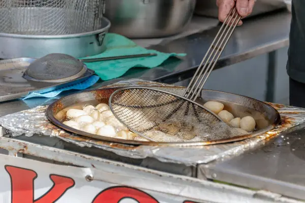 Sokak satıcısı lezzetli Loukoumades hamur topları hazırlıyor. Kıbrıs