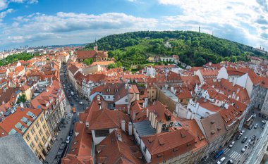 Prag 'ın panoramik manzarasında kırmızı çatılar, Petrin tepesi ve güneşli bir yaz gününde trafik görülüyor.