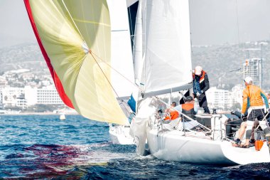 Yelkenli takımı yelkenli yarışında manevra yapıyor.