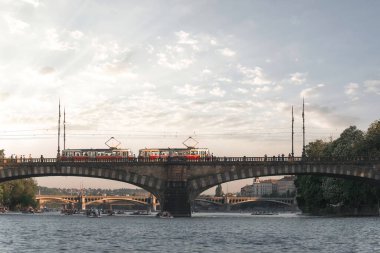 Vltava Nehri 'nin üzerinden geçen iki tramvay Prag' da suyun tadını çıkarıyor. Çek Cumhuriyeti