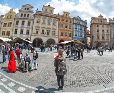 Prag, Çek Cumhuriyeti - 21 Mayıs 2019: Gezgin tarihi binalarla çevrili Eski Şehir Meydanı 'nda duruyor ve bir harita okuyor