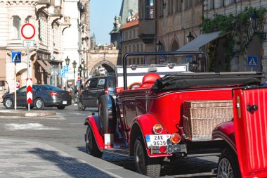 Prag, Çek Cumhuriyeti - 18 Mayıs 2019: Prag sokaklarına park edilmiş klasik kırmızı araba zamanda nostaljik bir yolculuk sunuyor
