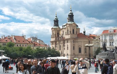 Prag, Çek Cumhuriyeti - 25 Mayıs 2019: Arka planda Aziz Nicholas Kilisesi ile Eski Şehir Meydanı 'ndaki atmosferi emen turistler