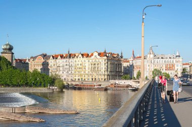 Prag, Çek Cumhuriyeti - 18 Mayıs 2019: Prag 'da güneşli bir günde Vltava Nehri üzerindeki bir köprüde yürüyen turistler