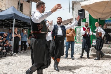 Dora (Dhora), Limassol District, Cyprus - May 28, 2023: Group of men wearing traditional Cypriot costumes performing a lively dance at Dora's Revival Festival clipart