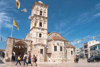 Larnaca, Kıbrıs - 16 Nisan 2022: Saint Lazarus Kilisesi önünde yürüyen turistler