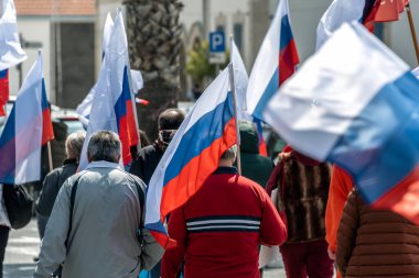 Larnaca, Cyprus - March 26, 2022: Crowd of people walking on street holding Russian flags during Pro-Russian Rally in Larnaca clipart