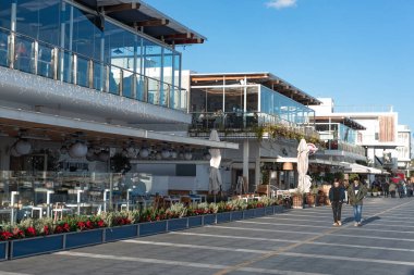 Limasol, Kıbrıs - 29 Aralık 2016: Limasol Eski Limanı 'nda güneşli bir günde modern restoranların önünden geçen insanlar