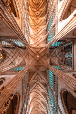 Güneş ışığı, ortaçağ gotik St. Vitus Katedrali 'nin kubbeli tavanını aydınlatan boyalı cam pencerelerden süzülür. Prag, Çek Cumhuriyeti