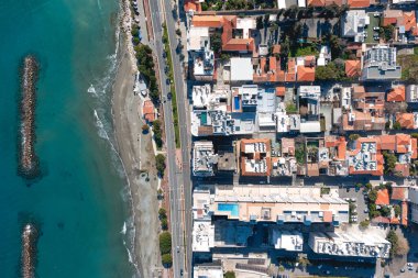 Güneşli bir günde sahil kenti Limasol 'un deniz manzarası, binalar ve dalgalı sular. Kıbrıs