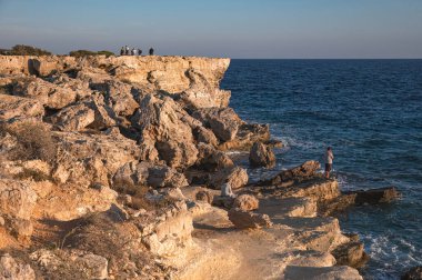 Turistler Kıbrıs Rum Kesimi 'nin Protaras kentindeki Kiklops Mağarası yakınlarındaki bir tepeden Akdeniz üzerinde gün batımının keyfini çıkarıyorlar. Famagusta Bölgesi