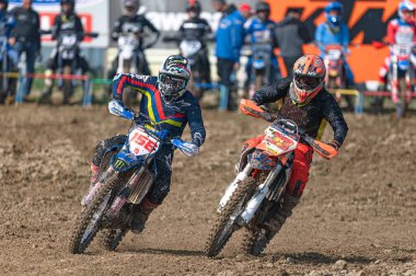 Agios Sozomenos, Kıbrıs - 11 Şubat 2024: Kıbrıs Rum Kesimi MX-PRO Şampiyonası sırasında yarışan iki motosiklet yarışçısı ellerinden geleni yapıyorlar