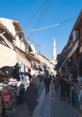 Lefkoşe, Kıbrıs - 24 Mart 2015: Güneşli bir günde Lefkoşe 'de dar bir Arasta caddesinde dükkanlar ve minarelerle yürüyen insanlar